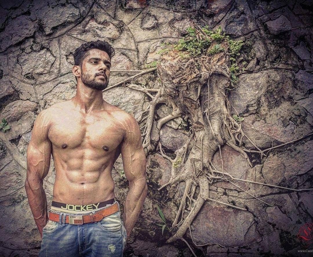 Abhinav Anand holding dumbbells in a dark gym